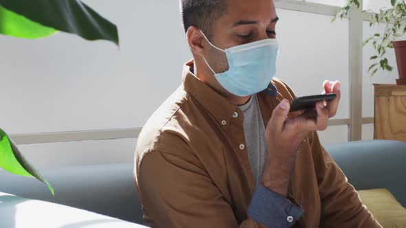 Man wearing face mask talking on smartphone at office