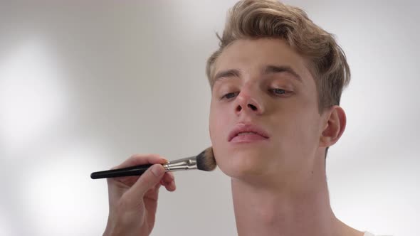 Male Makeup Artist Working on Model Face