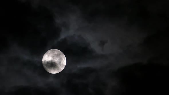 Full Moon Moving Between Clouds