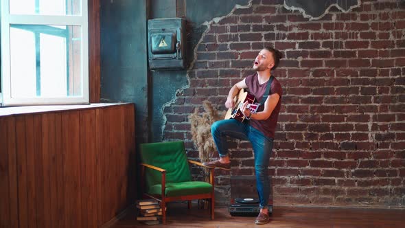 Man with Acoustic Guitar Against Brick Wall Playing Music Singing Songs Enjoy Life Medium Shoot