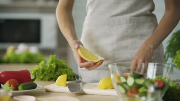Chef Cooking and Seasoning Salad with Fresh Lemon Juice, Girl Cutting Fruit
