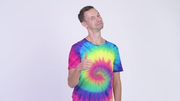 Studio Shot of Happy Man with Tie-dye Shirt Giving Thumbs Up