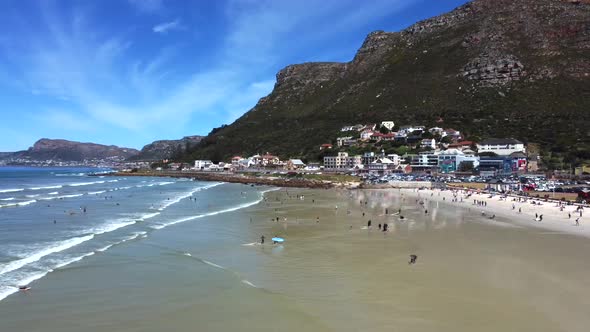 Side drone shot of surfers at Muizenberg beach, Cape Town - docents of surfers in the water. Snippet