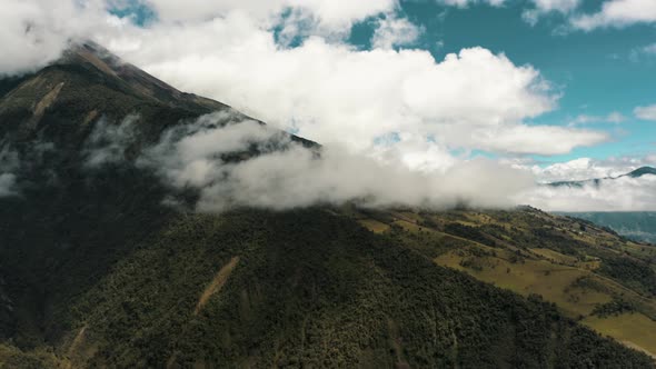 Rainforest On Lush Valley With Tungurahua Volcano Covered With Cloudscape In Ecuador. Aerial Drone S