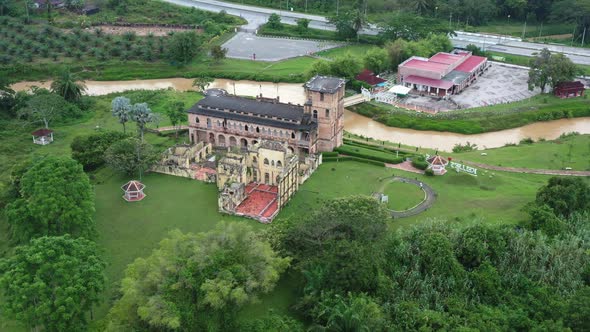 Riverside old Scottish folly, drone fly around the ruined section of Kellie's Castle on green lawn a