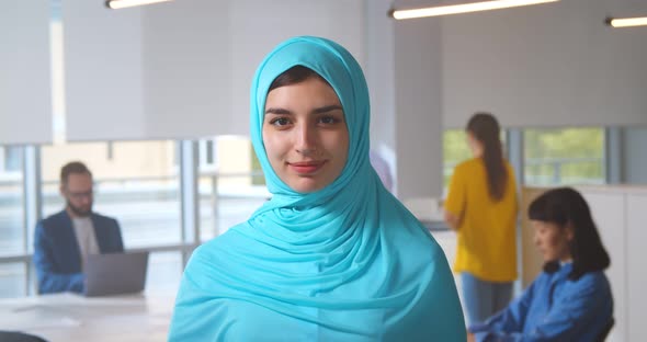 Portrait of Young Muslim Woman Wearing Hijab in Office Looking at Camera