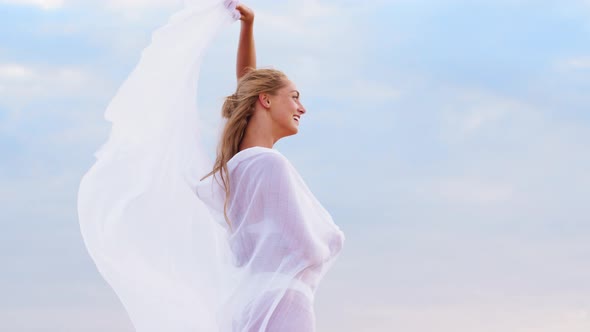 Happy Woman with Shawl Waving in Wind on Beach 