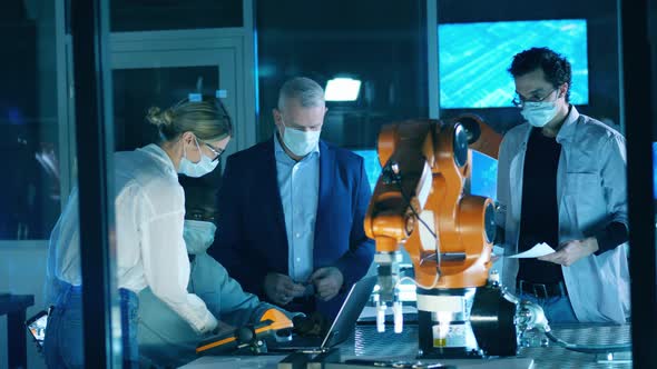 Robotic Laboratory with Engineers in Face Masks Working in It