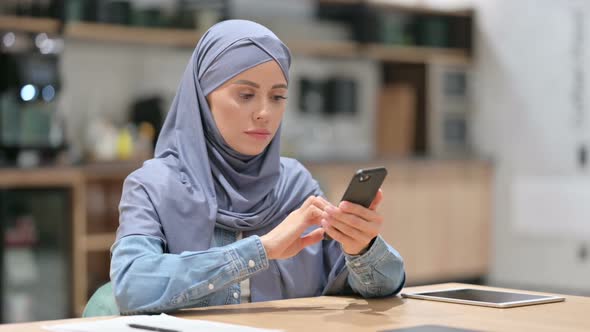 Attractive Arab Woman Using Smartphone at Work