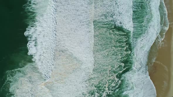 Aerial Top View on Ocean Waves and Sand Beach