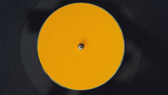 Black Vinyl Retro Record Rotating Plate with Yellow Label on Old DJ Turntable Player