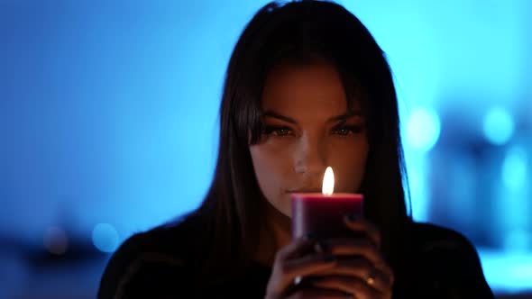 Mysterious Woman Is Looking Into Candle Burning at Night Prophecy and Fortune Telling