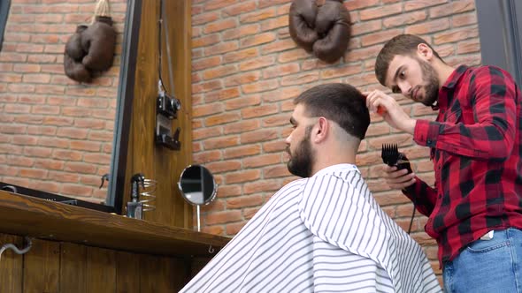 A Man Gets a Haircut in a Stylish Barbershop