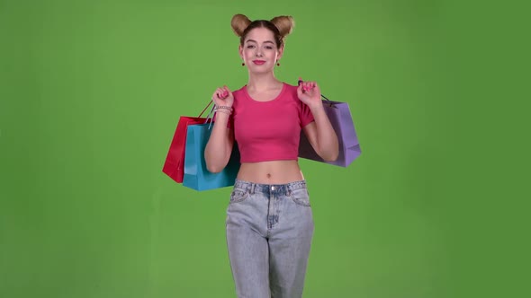 Teenager Goes Shopping with Bags in His Hands. Green Screen. Slow Motion