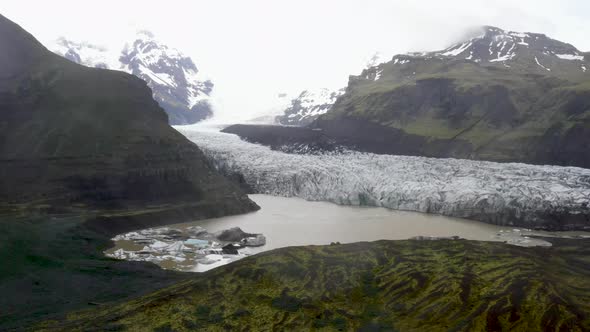 Glacier in Iceland with water and mountains with drone video moving up close view.