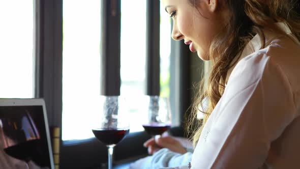 Woman siting in a restaurant and using laptop