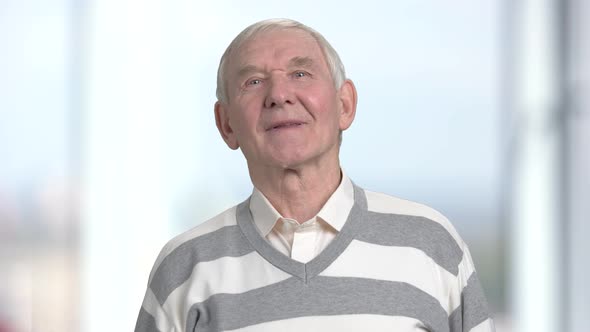 Retired Man Posing on Blurred Background.