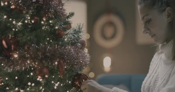 Young woman making christmas tree decoration.