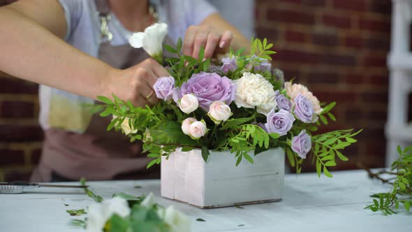 Professional Florist Arranging Flower Composition in Wooden Box