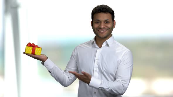 Smiling Indian Guy Presenting Gift Box.