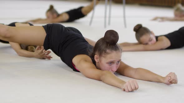 Girl Lying on Floor and Practicing Splits
