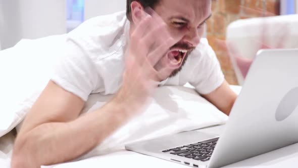 Screaming Man Using Laptop in Bed