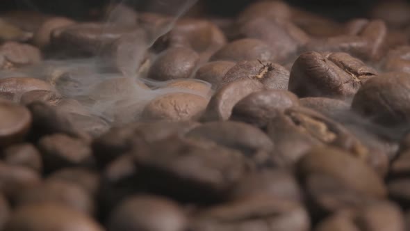 Close up slow motion shot of smoke released during the roasting of organic coffee beans. The exother