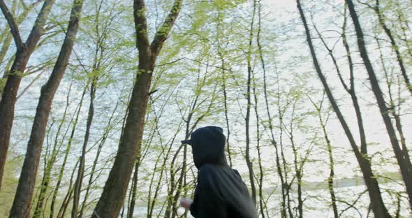 Young Girl Athlete Runs in the Woods in Headphones Alone