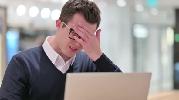 Young Businessman with Laptop Having Headache