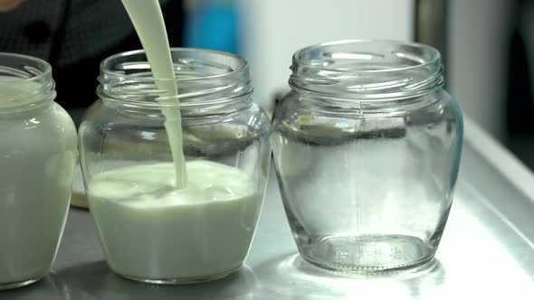 Close Up Glass Jars Filling with Fresh Milk