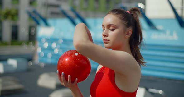 Portrait of Woman in Red Sports Costume Performing Callisthenics Exercises with Gymnastic Ball