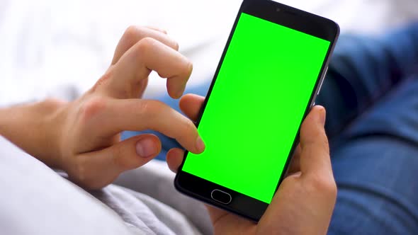 Black Smartphone with Green Screen for Chroma Key Compositing the Hands of a Man Swipe Up on