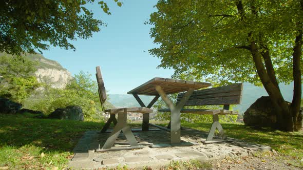 Lawn with Table and Benches in Park Against Country Valley