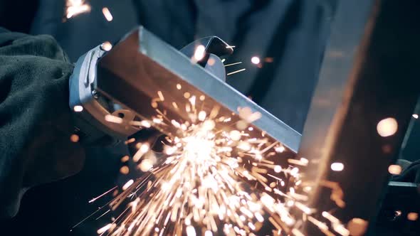 Professional Welder Cuts Metal with Angle Grinder