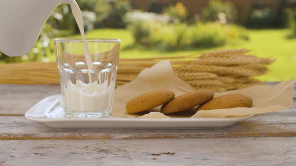 Hand Pouring Milk Into a Glass