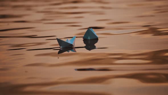 Evening water background and two paper boats swimming.