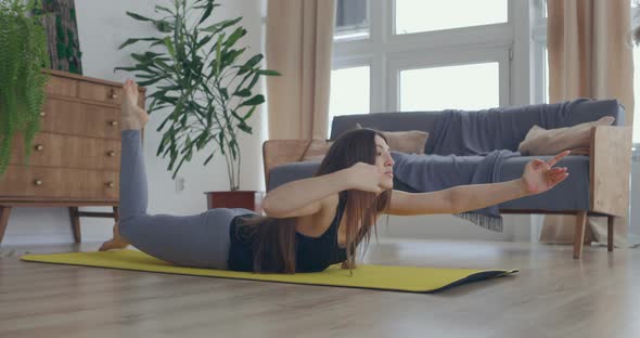 Healthy and Pretty Woman Exercising at Home Practicing Stretching in Living Room Enjoying Morning