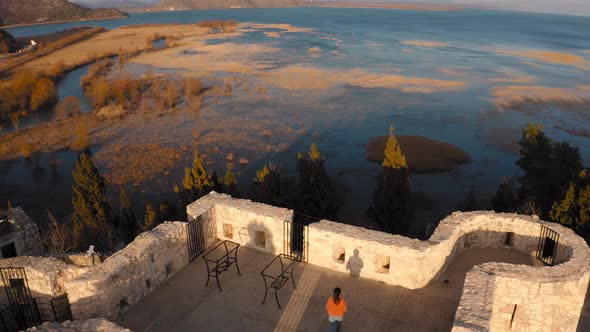 A mesmerizing view of tourist on roof of Besac fortress beside vast Lake Skadar, Montenegro. Aerial.