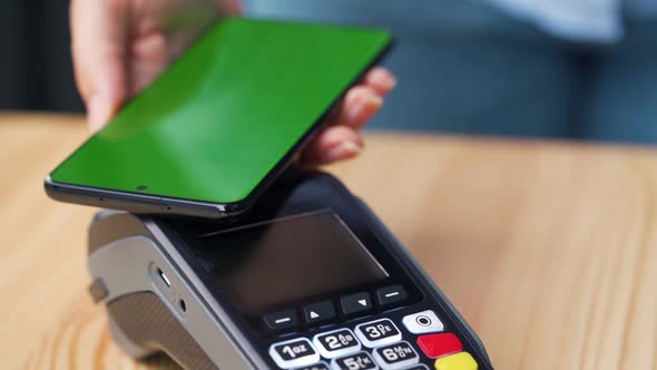 Contactless Payment with Smartphone with Green Mock-up Screen. Wireless Payment Concept. Close-up