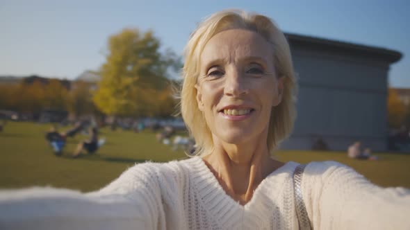 Pov Shot of Happy Beautiful Retired Woman Whirling and Smiling in City Park