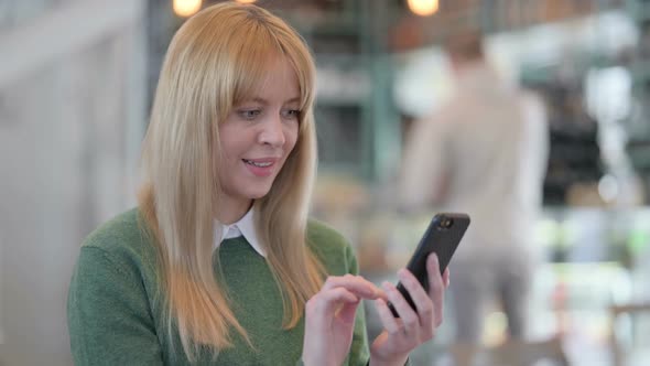 Portrait of Young Woman Celebrating on Smartphone