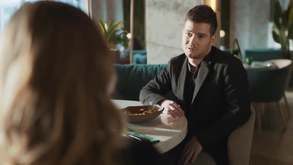 Portrait of Suit Wearing Young Adult Business Partners Colleagues Sitting at Table in Restaurant