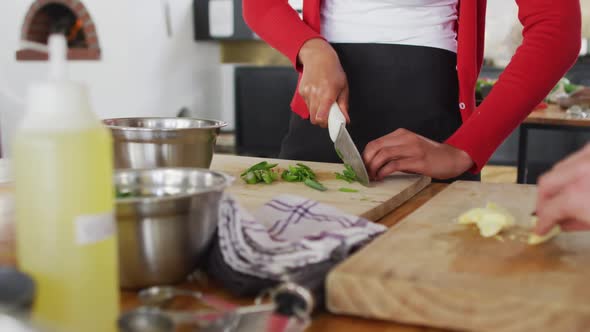 Diverse group wearing face masks cutting vegetables