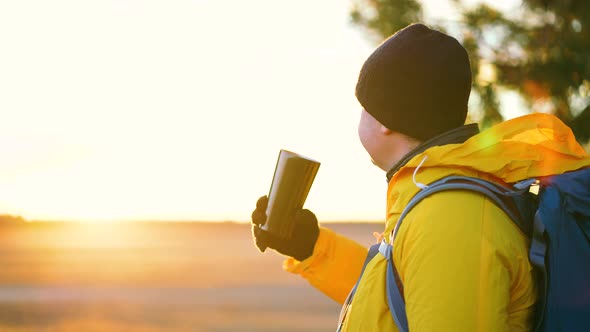 Hiker Young Tourist Enjoying Nature Drinking Hot Tea at Sunset