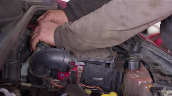 Mechanic At The Repair Shop Installing The New Air Filter