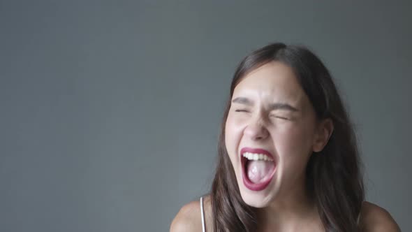 Portrait of Screaming Loud Young Brunette Female with Red Lips Wide Opened Mouth