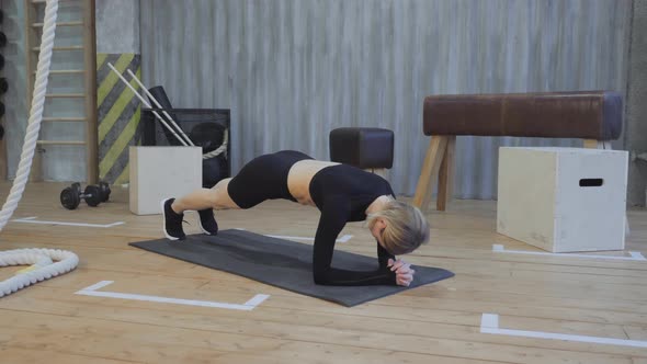 Beautiful and Young Girl Does Plank on Her Fitness Mat. Athletic Woman Does Workout