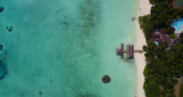 Natural drone tourism shot of a white sand paradise beach and blue sea background in vibrant