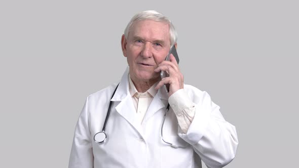 Portrait of Smiling Senior Doctor Talking on Mobile Phone.