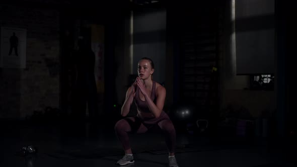 Wide Shot Portrait of Confident Fit Sportswoman Jumping in Squatting Position in Slow Motion